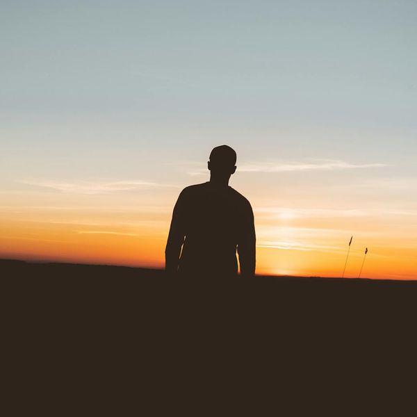 Silhouette of a person meditating against a natural backdrop.